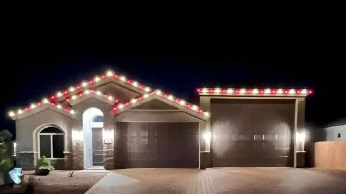 Single-story stucco home at night with a red and warm white C9 roofline along every gable and the garage
